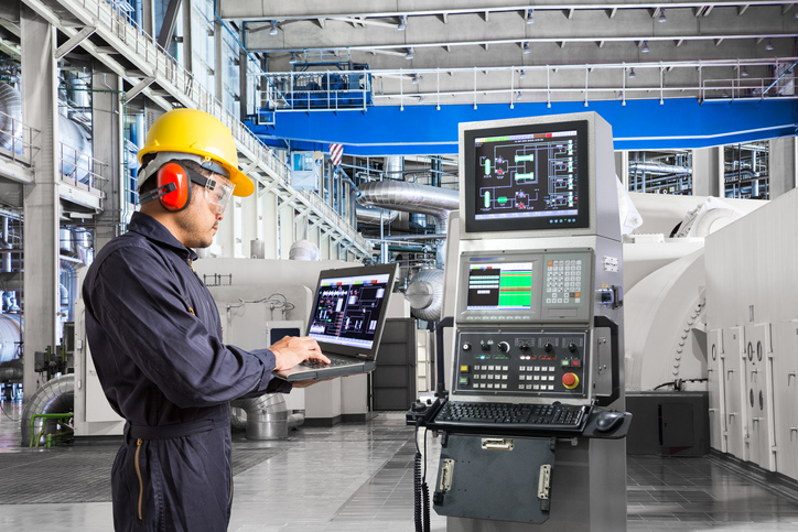 Engineer using computer for maintenance equipment in powerhouse nuclear industry repair and maintenance services